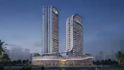 Radisson Blu Hotel and Residences twin towers illuminated at dusk in RAK Central